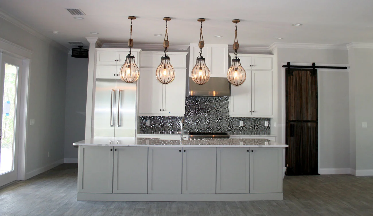 Kitchen with white cabinetry, an island and pendant lights